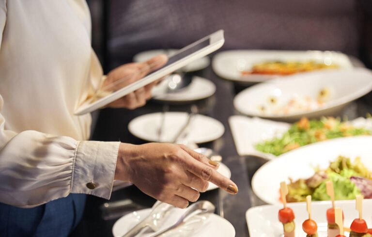 event planner pointing to dishes with food on a table